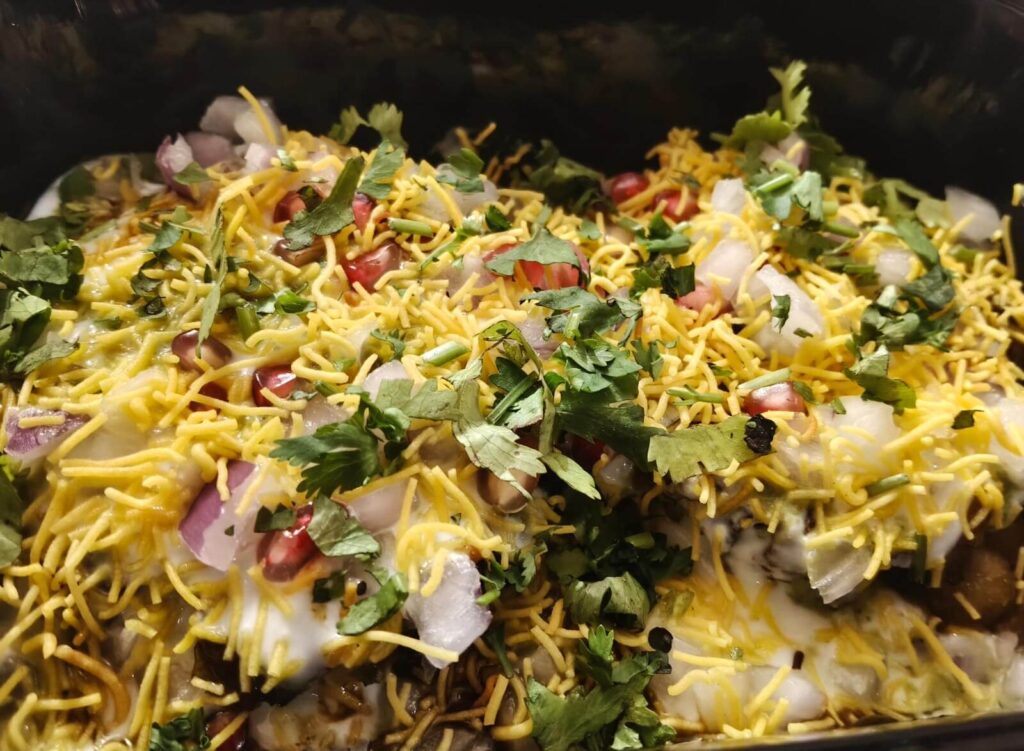 Aloo Tikki Chole Chaat served hot with crispy tikki, spicy chole and fresh toppings at Rounder Chatore.
