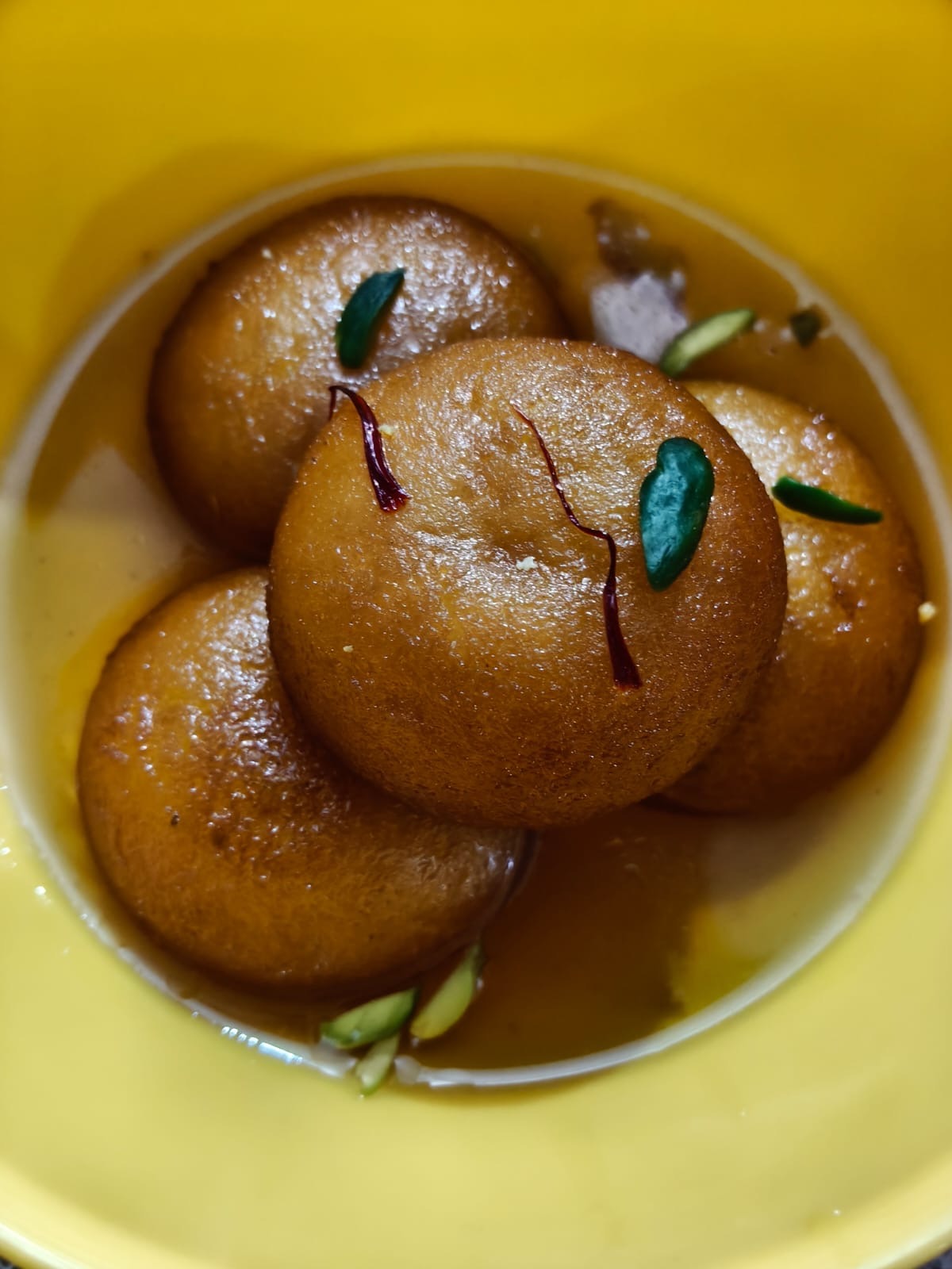 Sweet, juicy malai gulab jamun topped with pistachios.