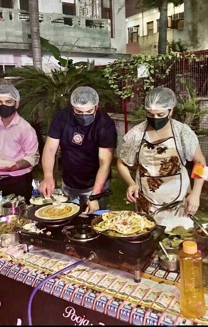 Chefs preparing fresh dosa and pasta at a live catering counter during an outdoor event in Zirakpur.